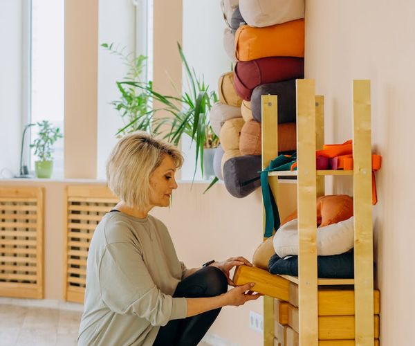 Cozy corner of a room with a yoga mat, cushion, and a plant.